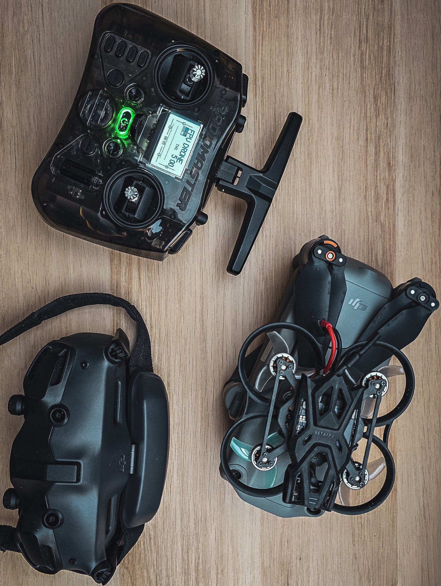 FPV-setup op tafel: de zender, de bril en twee drones