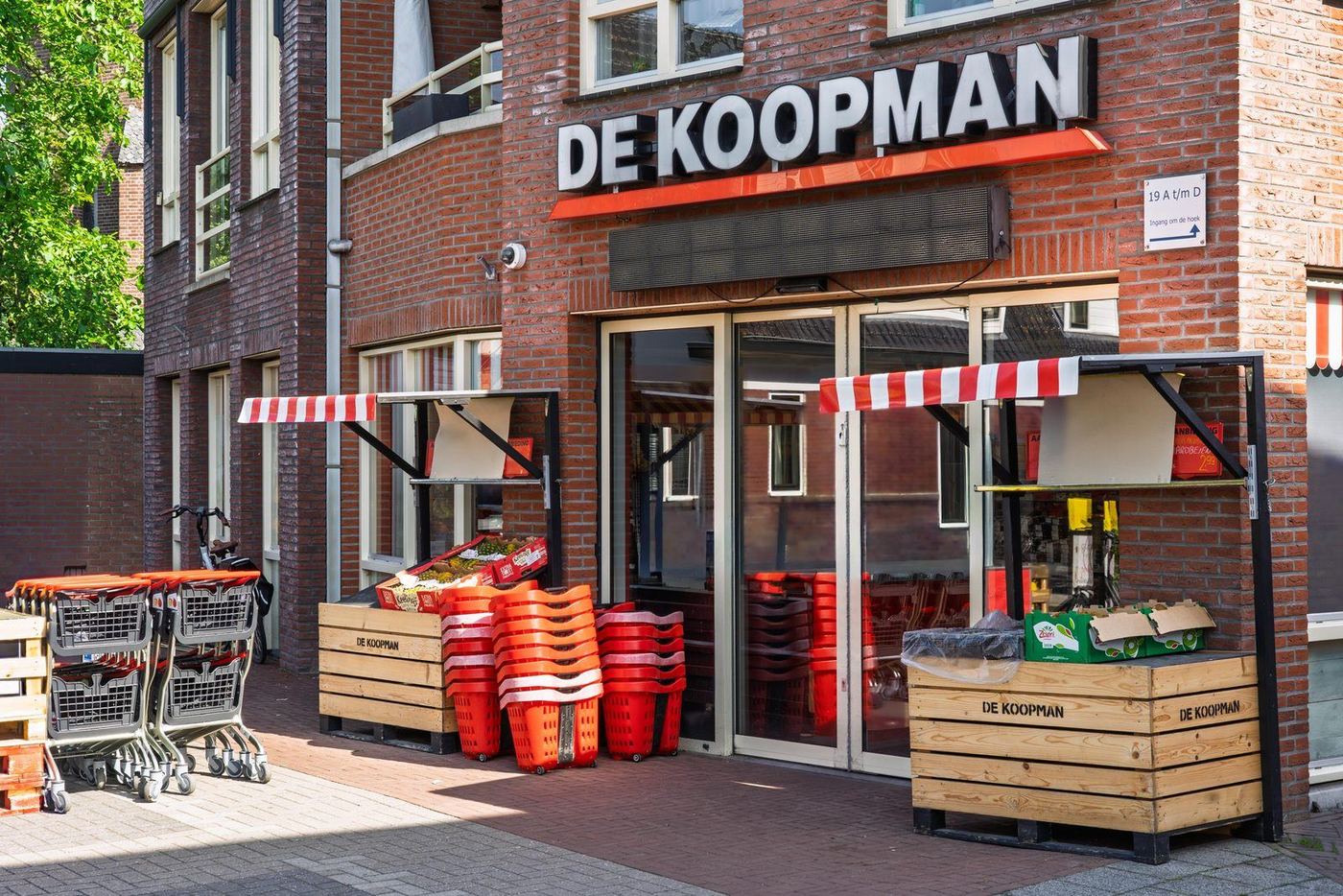 Gevel van groentewinkel De Koopman met kratten en winkelwagens