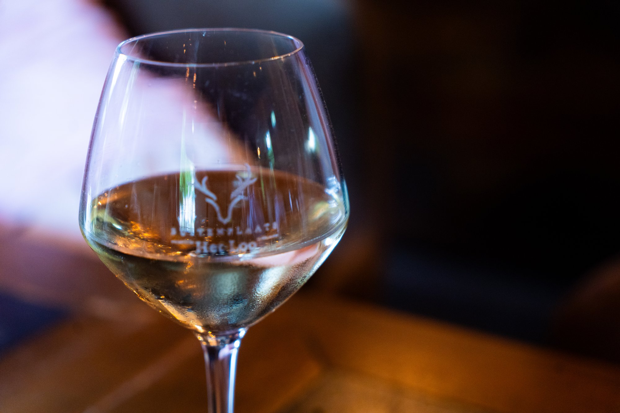 Glas witte wijn met het logo van Buitenplaats Het Loo